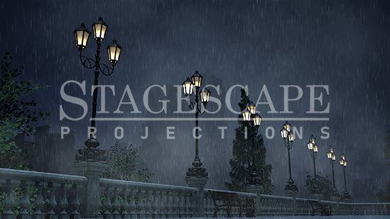 Paris Riverside Promenade static scenic projection backdrop for & Juliet — oil lamps along the Seine with Notre Dame in the distance. Five lighting states from dusk to night. StageScape Projections.