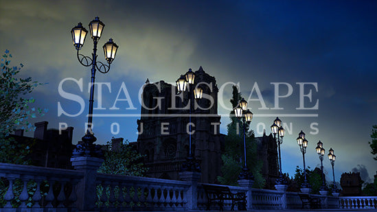 Paris Riverside Promenade static scenic projection backdrop for & Juliet — oil lamps along the Seine with Notre Dame in the distance. Five lighting states from dusk to night. StageScape Projections.
