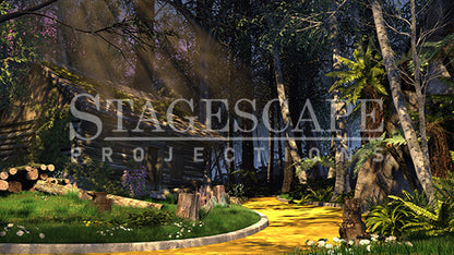 The TinWoodman's Cottage scenic projection backdrop for The Wizard of Oz - dark log cottage with moss and purple flowering boughs, kerbed yellow brick road, stark white birch trees and cascading ferns against deep forest. StageScape Projections.